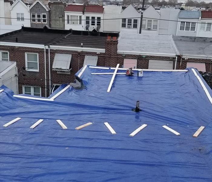 SERVPRO remediating the roof with tarps to prevent further leaks