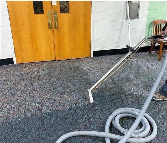 A technician extracting water from a carpet